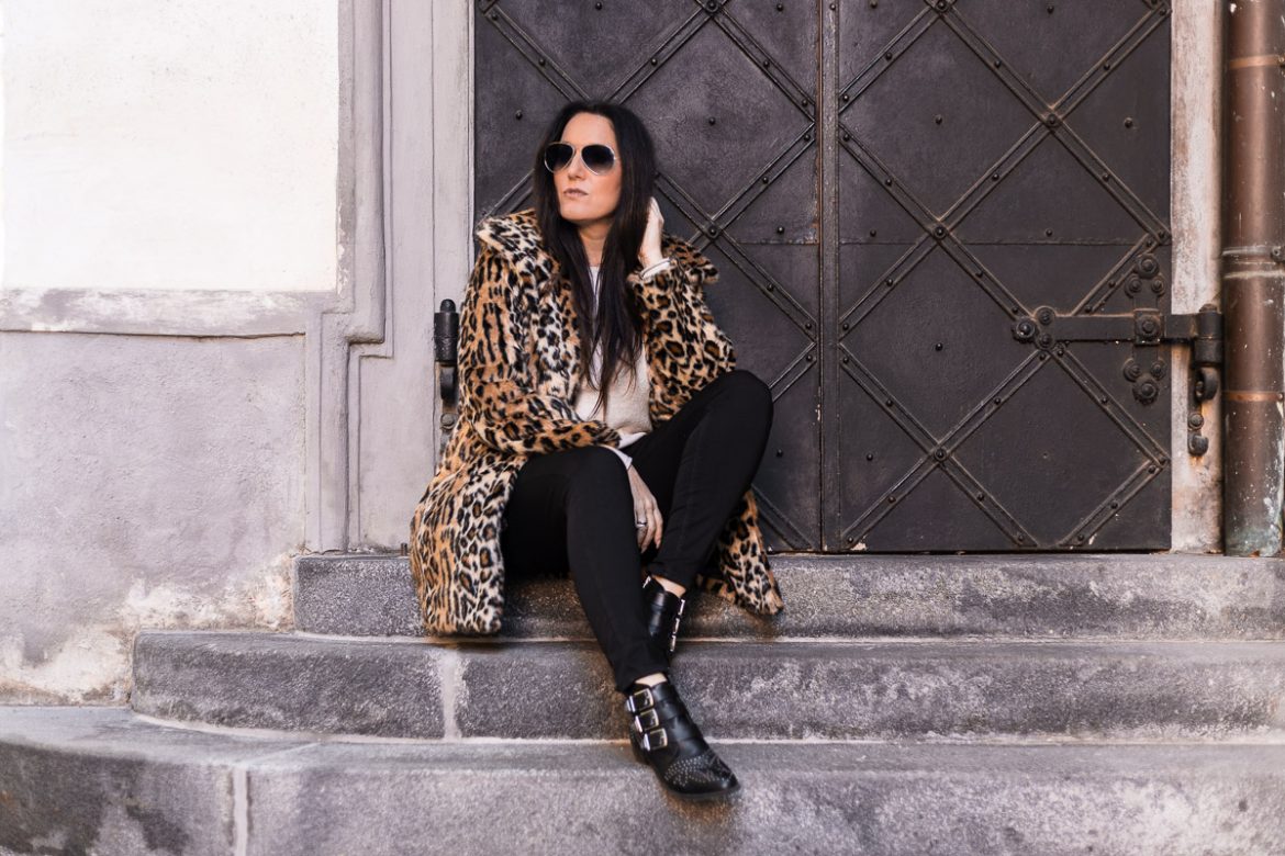 Leo Mantel mit Statement Moschino Gürtel: Fashion Bloggerin Miss Classy aus Graz trägt einen Leo Mantel einem Statement Moschino Gürtel, eine skinny Jeans und Nieten Boots. Die Handtasche ist von Michael Kors
